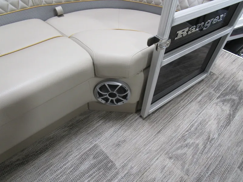 Slide: The Image of 2024 Ranger Reata 243C boat interior with beige seating and speaker detail. - 11
