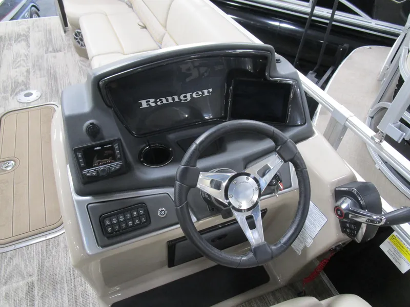 Slide: The Image of 2024 Ranger Reata 243C boat dashboard with steering wheel and control panel. - 15