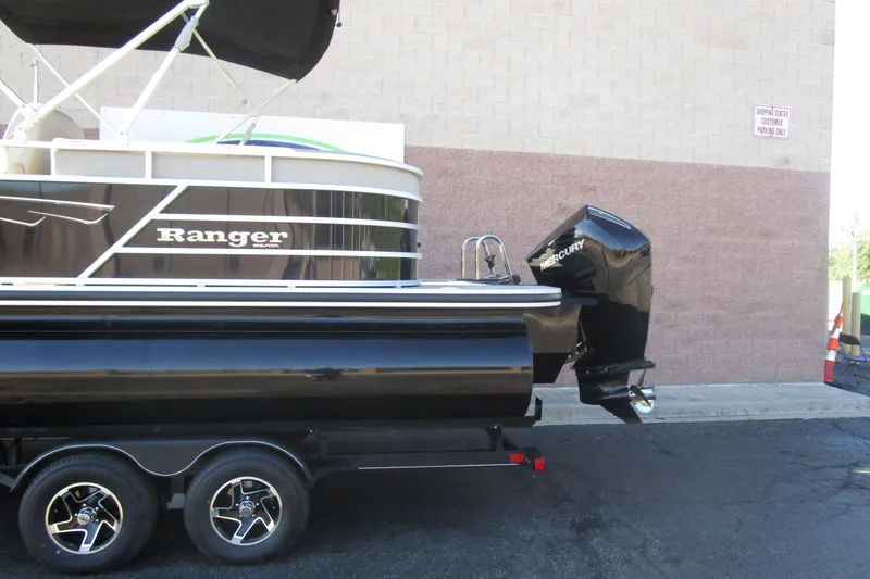 Slide: The Image of 2024 Ranger Reata 243C boat with Mercury outboard motor on trailer. - 2