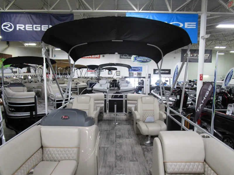 Slide: The Image of 2024 Ranger Reata 243C pontoon boat interior with seating and canopy in showroom. - 20