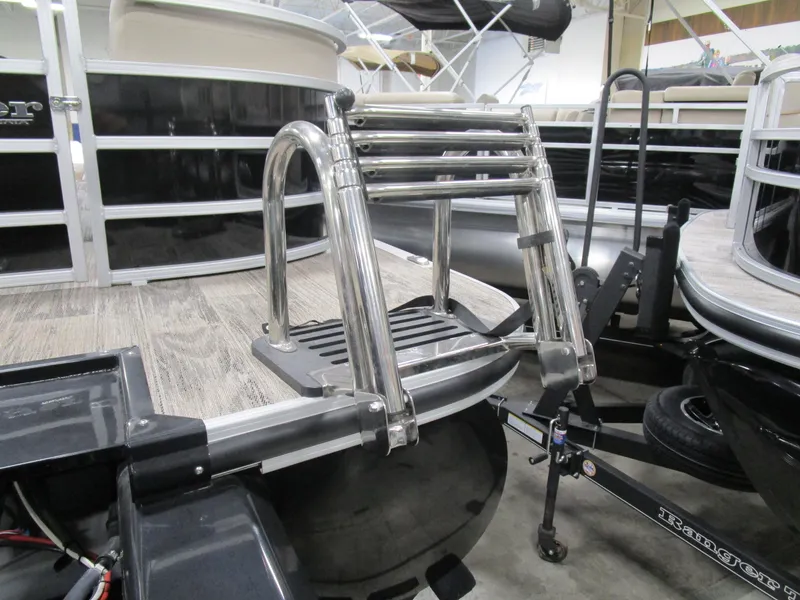Slide: The Image of 2024 Ranger Reata 243C boat ladder on a trailer in a showroom. - 22