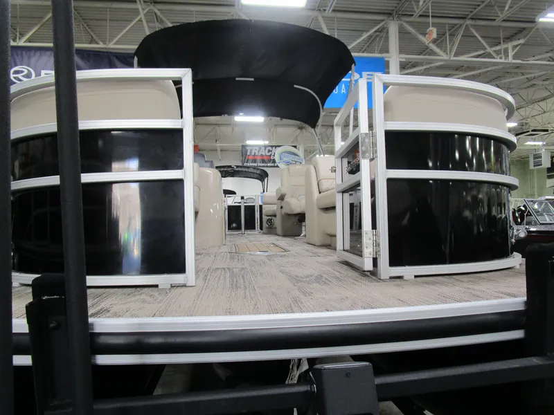 Slide: The Image of 2024 Ranger Reata 243C pontoon boat with spacious seating, displayed indoors. - 8