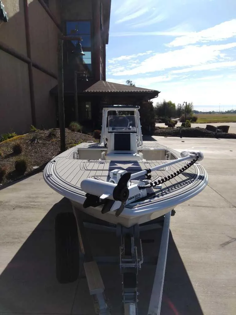 Slide: The Image of 2025 Mako 18 Pro Skiff Patriot Edition boat on trailer, outdoor setting. - 1