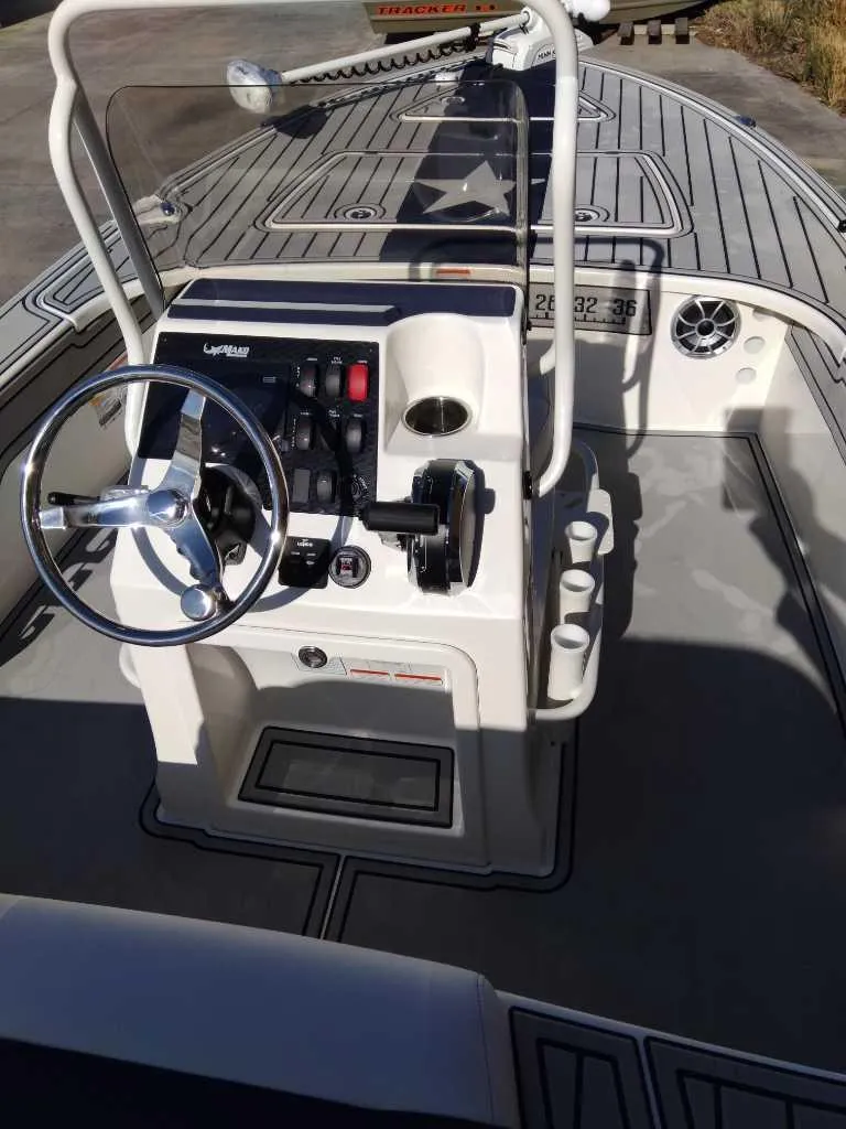 Slide: The Image of 2025 Mako 18 Pro Skiff Patriot Edition boat interior with steering console and controls. - 2