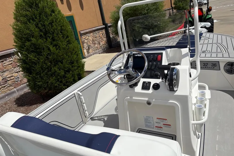 Slide: The Image of 2025 Mako 18 Pro Skiff Patriot Edition boat interior with steering console and controls. - 7