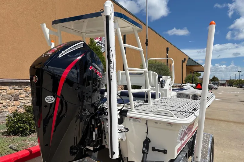 Slide: The Image of 2025 Mako 18 Pro Skiff Patriot Edition with Mercury Pro outboard motor, parked outdoors. - 9