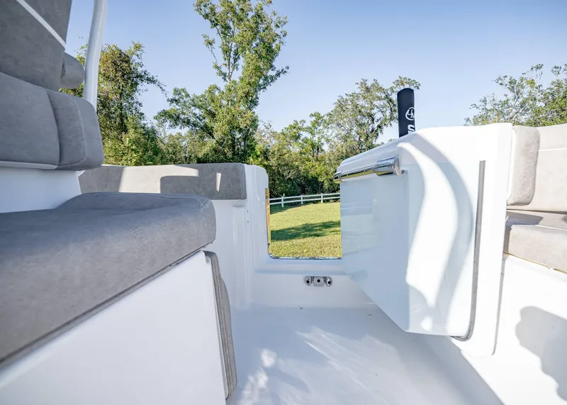 Slide: The Image of 2025 Sea Hunt Ultra 239 SE boat interior with cushioned seating and open door. - 13