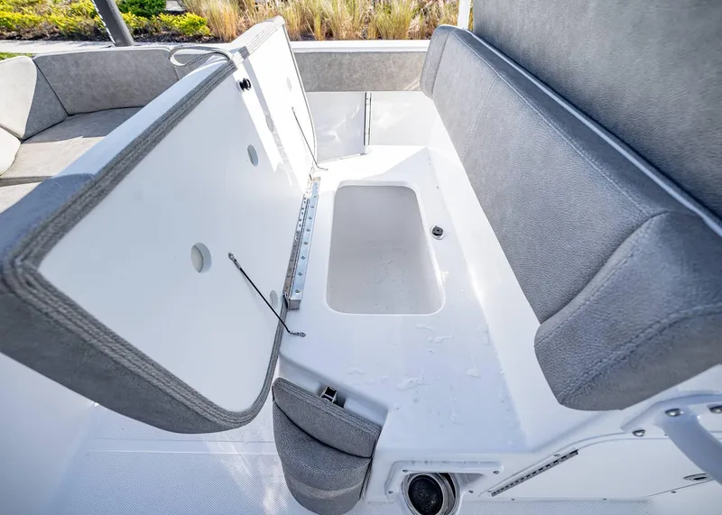 Slide: The Image of 2025 Sea Hunt Ultra 239 SE boat storage compartment with open lid and cushioned seating. - 15