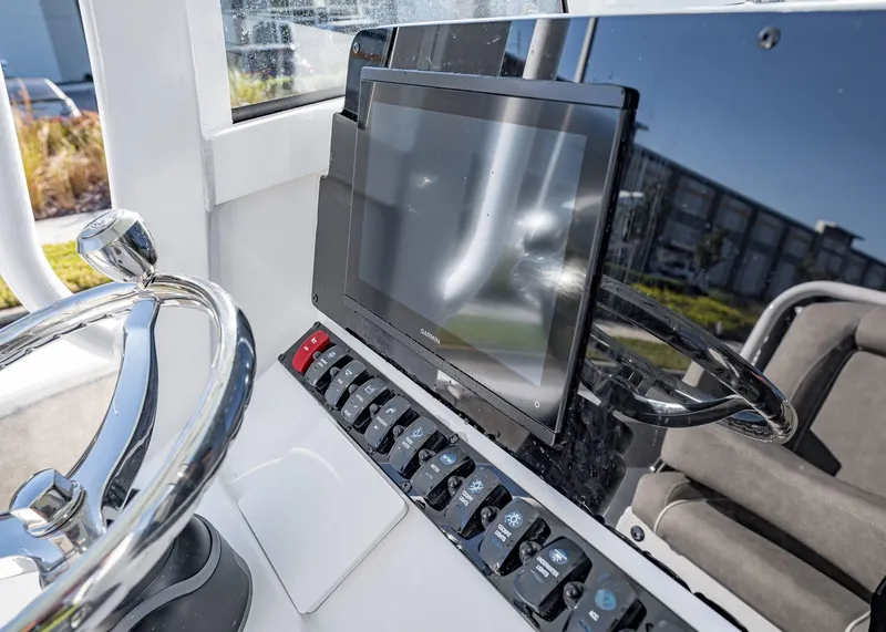 Slide: The Image of 2025 Sea Hunt Ultra 239 SE dashboard with steering wheel and touchscreen display. - 25