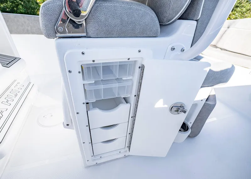 Slide: The Image of Storage compartment on 2025 Sea Hunt Ultra 239 SE boat with open door and drawers. - 29