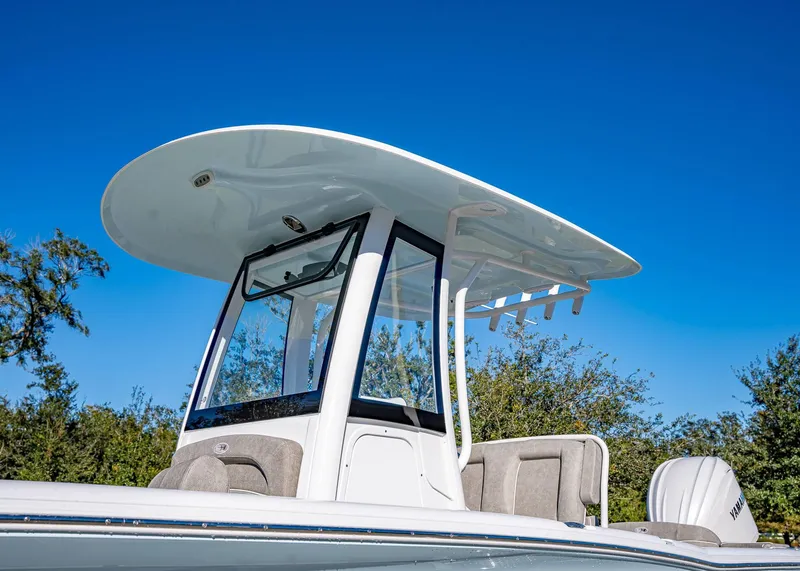 Slide: The Image of 2025 Sea Hunt Ultra 239 SE boat with T-top against clear blue sky. - 3