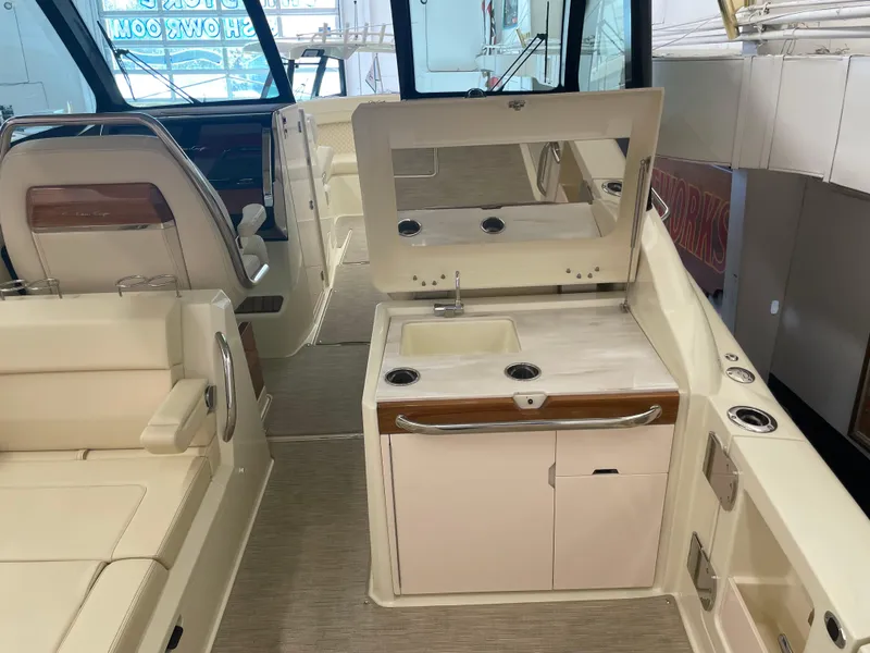 Slide: The Image of 2024 Chris-Craft Calypso 32 interior with seating and kitchenette area. - 14