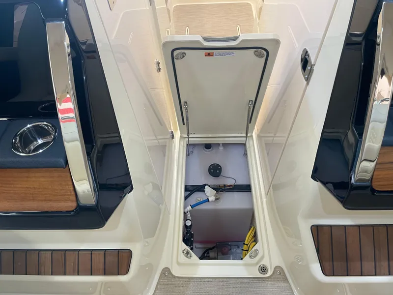 Slide: The Image of 2024 Chris-Craft Calypso 32 boat storage compartment with open hatch, showcasing interior details. - 28