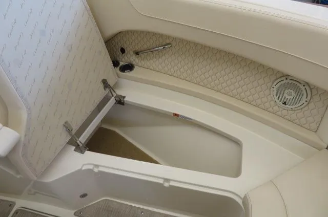 Slide: The Image of 2024 Chris-Craft Calypso 32 boat interior storage compartment with beige upholstery and speaker. - 44