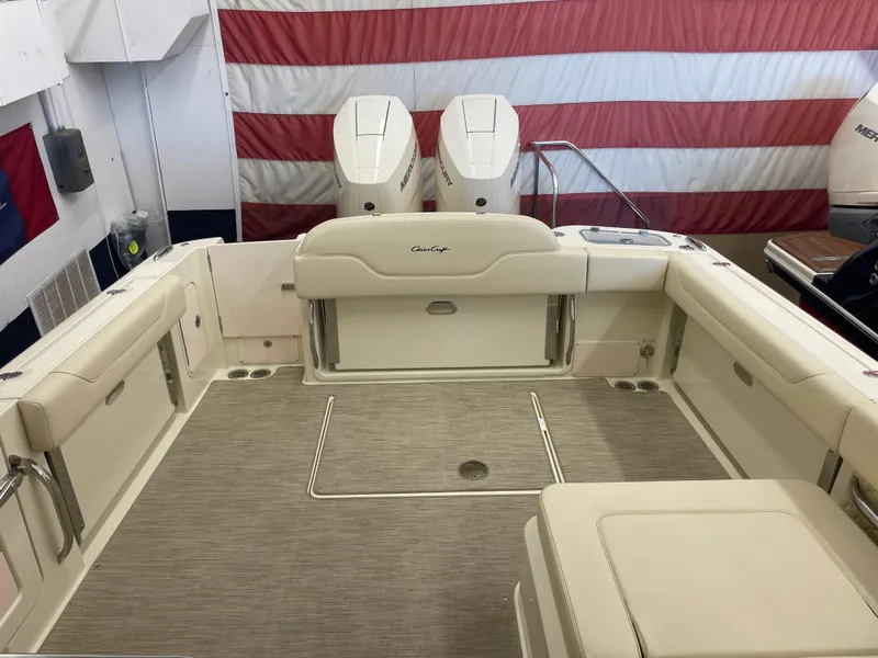 Slide: The Image of 2024 Chris-Craft Calypso 32 boat interior with twin engines and American flag backdrop. - 7