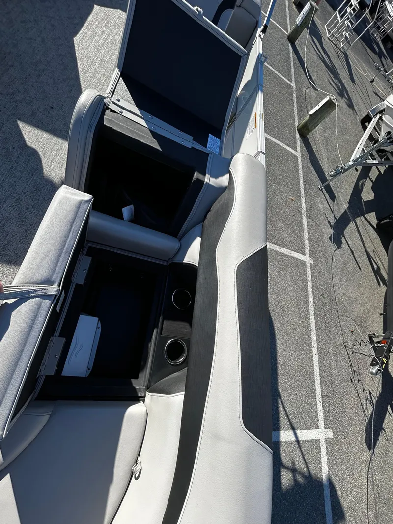 Slide: The Image of 2024 Berkshire 22RFX LE 2.75 boat interior with open storage compartments and cup holders. - 11