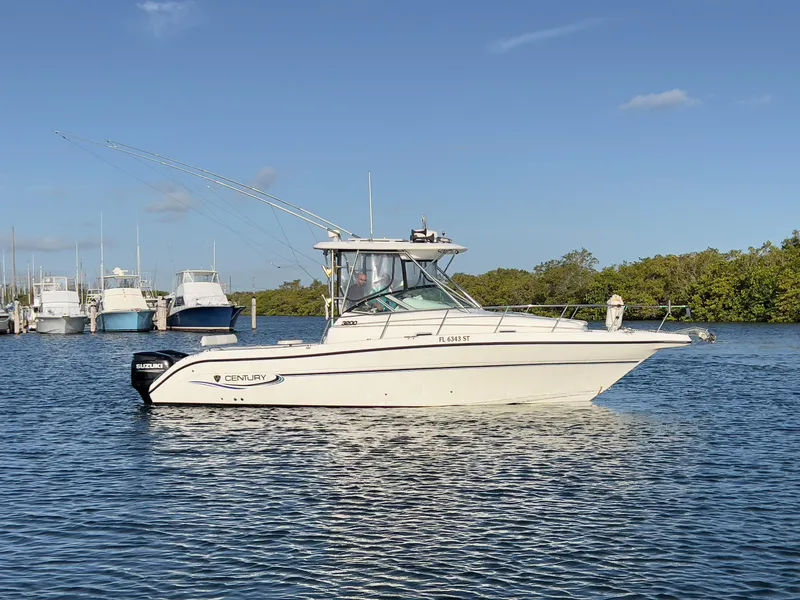 Slide: The Image of 2005 Century 3200 Walk-Around boat on calm water, clear sky background. - 1