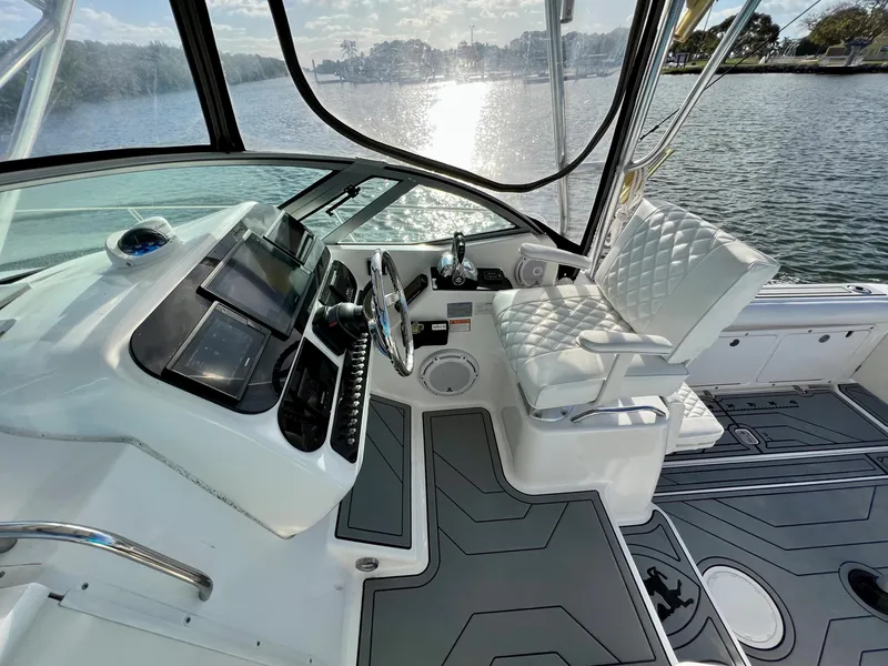 Slide: The Image of 2005 Century 3200 Walk-Around boat interior with helm and seating, overlooking water. - 19