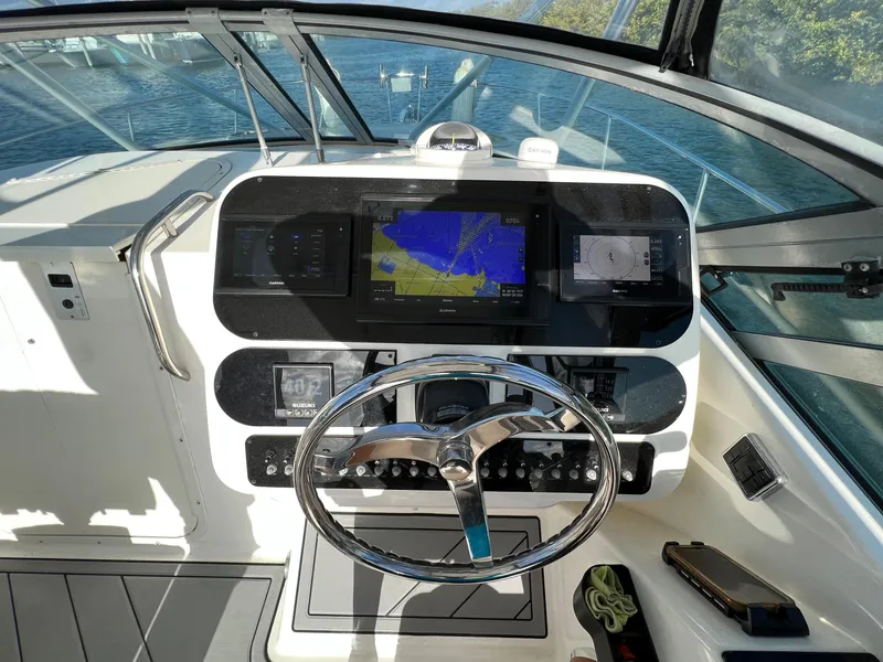 Slide: The Image of Century 3200 Walk-Around 2005 boat dashboard with navigation system and steering wheel. - 21