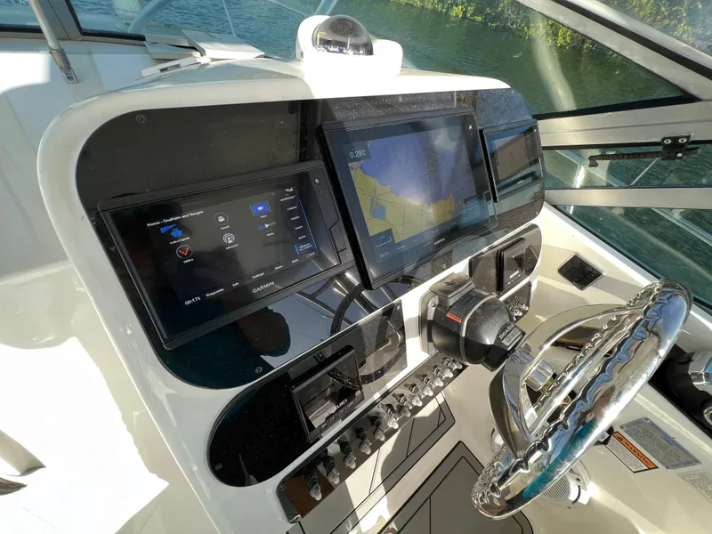 Slide: The Image of 2005 Century 3200 Walk-Around boat dashboard with navigation screens and steering wheel. - 22