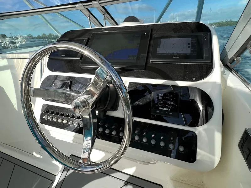 Slide: The Image of Century 3200 Walk-Around 2005 boat dashboard with steering wheel and control panel. - 23