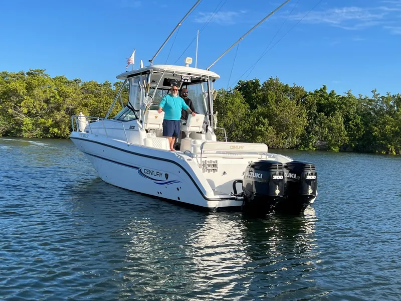 Slide: The Image of 2005 Century 3200 Walk-Around boat on water with dual Suzuki engines. - 3