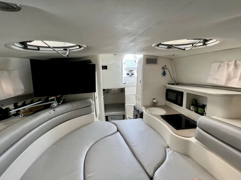 Slide: The Image of 2005 Century 3200 Walk-Around cabin interior with seating, kitchenette, and TV. - 34