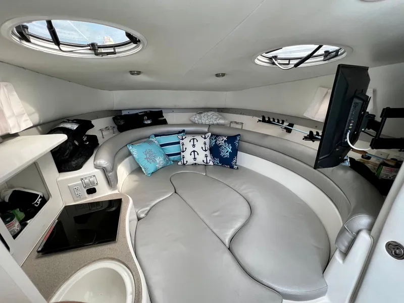 Slide: The Image of 2005 Century 3200 Walk-Around cabin interior with seating, pillows, and TV. - 35