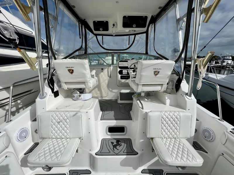 Slide: The Image of 2005 Century 3200 Walk-Around boat interior with white seating and dashboard. - 42