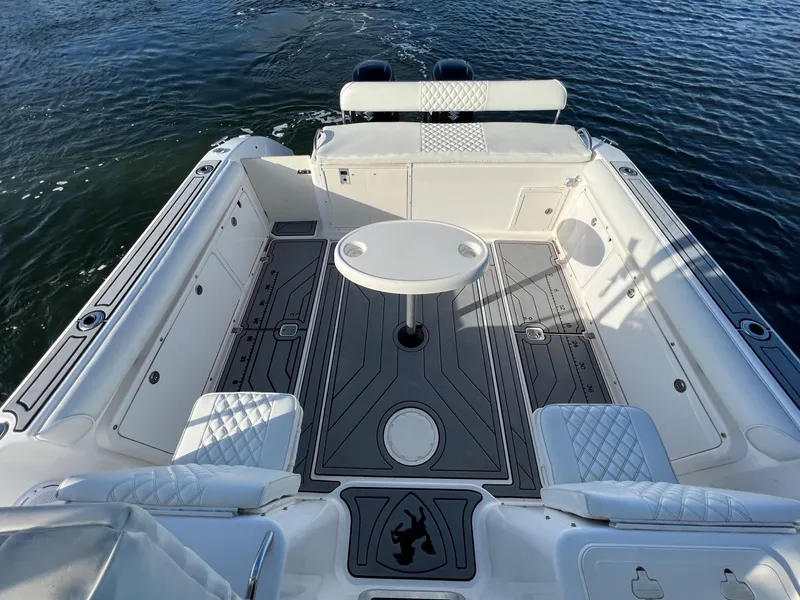 Slide: The Image of 2005 Century 3200 Walk-Around boat interior with seating and table on water. - 8