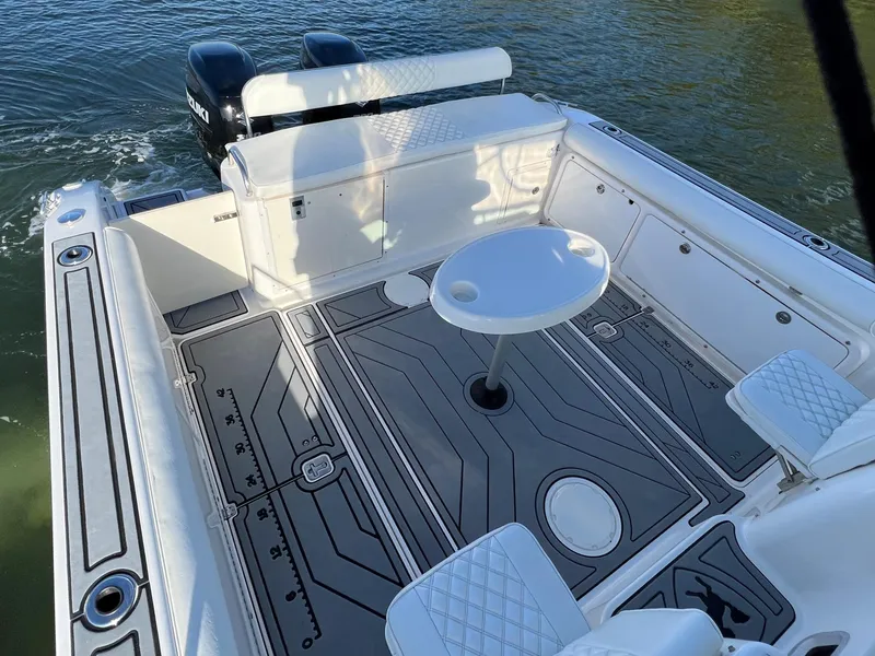 Slide: The Image of 2005 Century 3200 Walk-Around boat interior with seating and table on water. - 9
