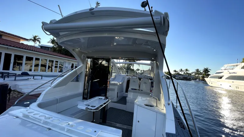 Slide: The Image of 2022 Evolve 400HT yacht docked by waterfront homes and palm trees. - 3