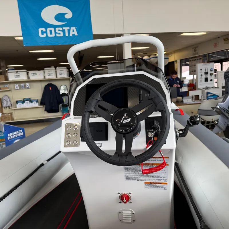 Slide: The Image of 2025 Highfield 420 Velox boat steering console in showroom with Costa banner. - 4