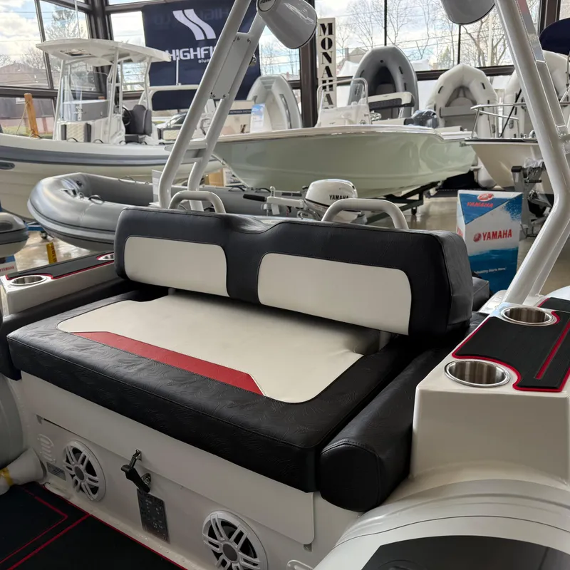 Slide: The Image of 2025 Highfield 420 Velox boat interior with seating and cup holders in showroom. - 9