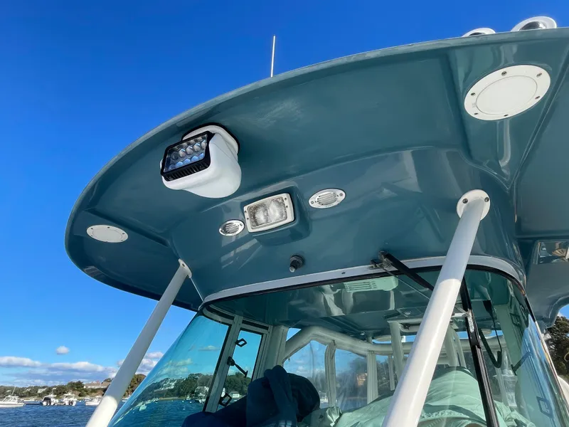 Slide: The Image of 2008 Everglades 350CC boat with blue canopy and lights, under clear sky. - 6