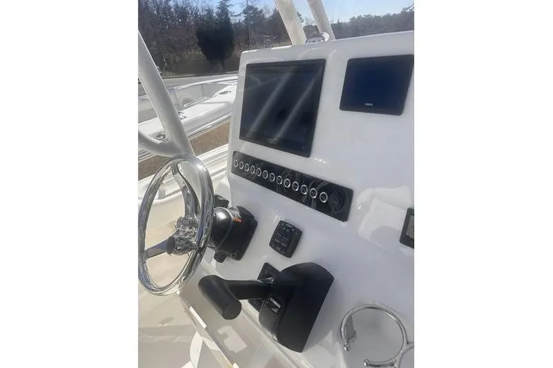 Slide: The Image of 2025 Key West 239 FS boat dashboard with steering wheel and control panel. - 13