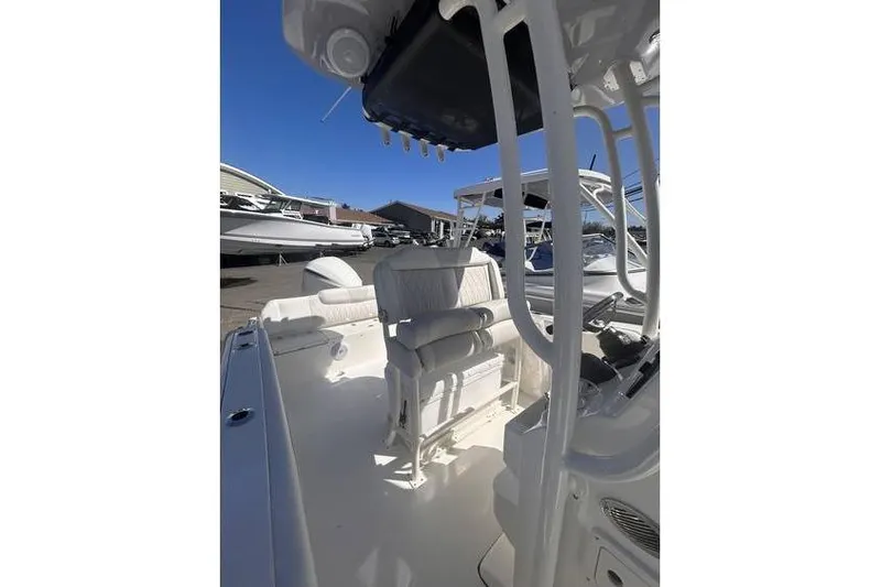 Slide: The Image of 2025 Key West 239 FS boat interior with seating and console, docked under clear blue sky. - 9