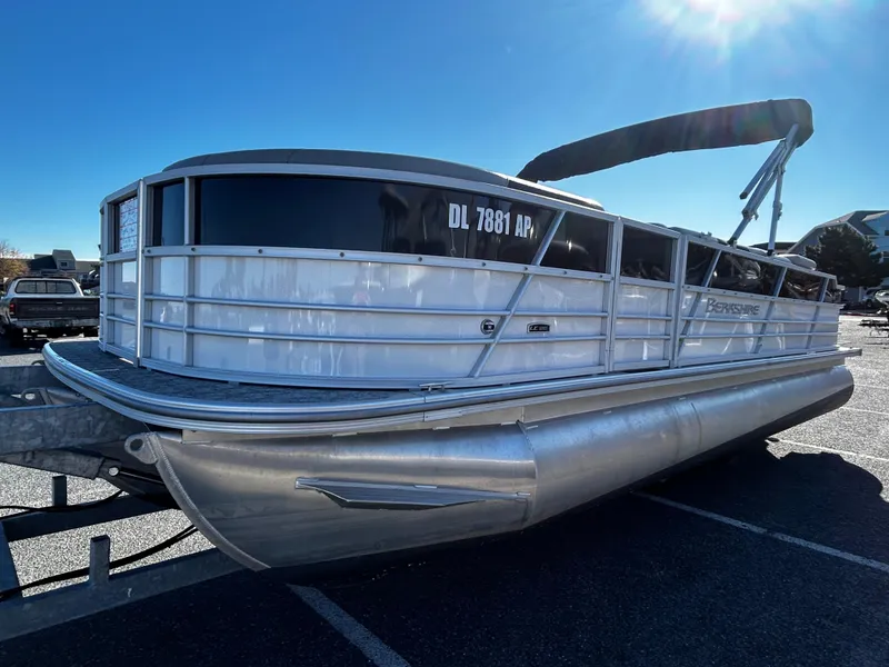 Slide: The Image of 2024 Berkshire 24RFC LE 2.75 pontoon boat in parking lot, side view. - 1