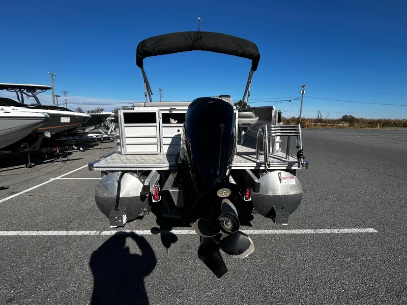 Slide: The Image of 2024 Berkshire 24RFC LE 2.75 pontoon boat with outboard motor, parked on asphalt. - 15