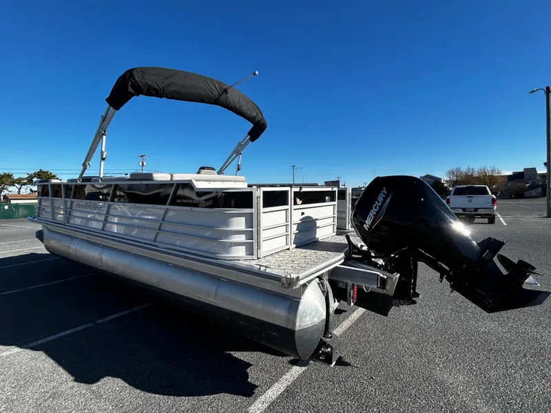 Slide: The Image of 2024 Berkshire 24RFC LE 2.75 pontoon boat with Mercury outboard motor in parking lot. - 5