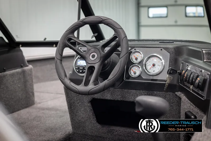 Slide: The Image of 2025 Lund 1875 Impact XS boat dashboard with steering wheel and gauges. - 23