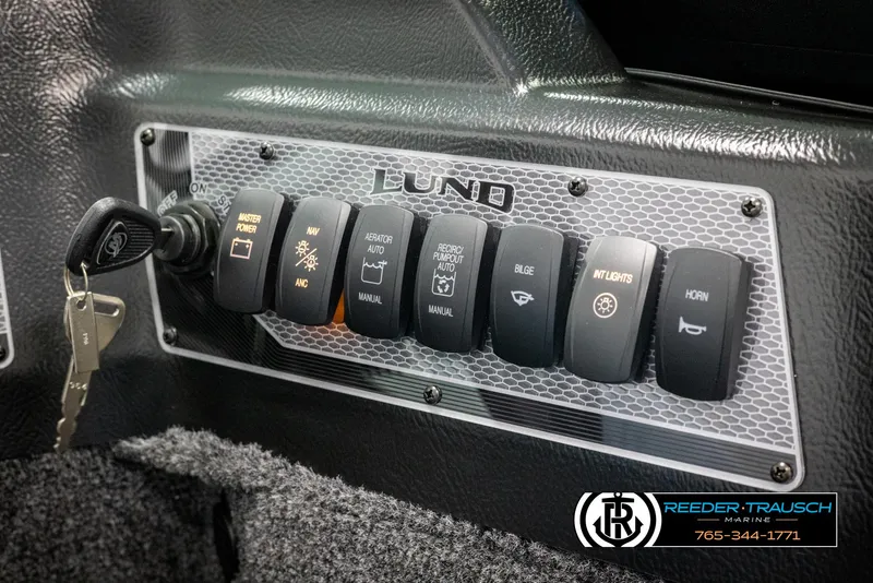 Slide: The Image of Control panel of 2025 Lund 1875 Impact XS boat with labeled switches and ignition key. - 28