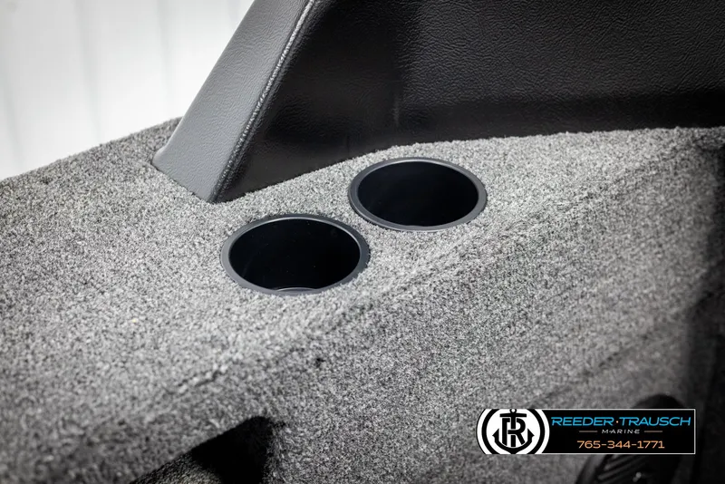 Slide: The Image of 2025 Lund 1875 Impact XS boat interior with dual cup holders, gray carpet finish. - 33