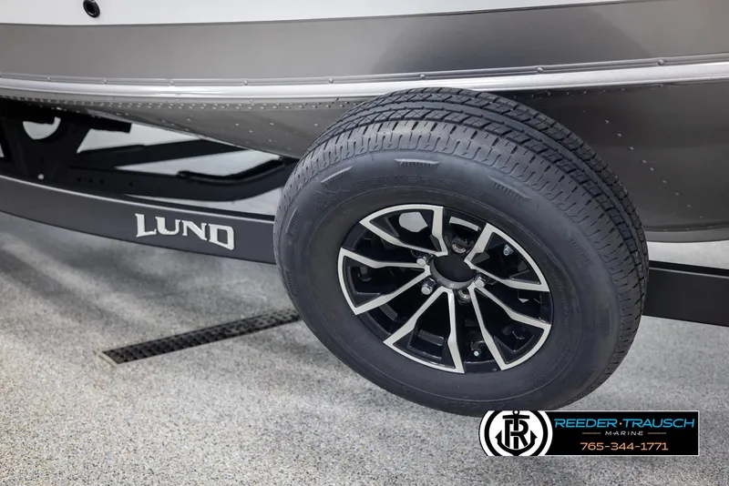 Slide: The Image of 2025 Lund 1875 Impact XS boat trailer wheel, featuring sleek black and silver design. - 45