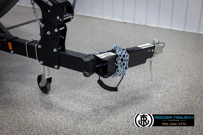 Slide: The Image of 2025 Lund 1875 Impact XS trailer hitch with safety chains in a showroom. - 47