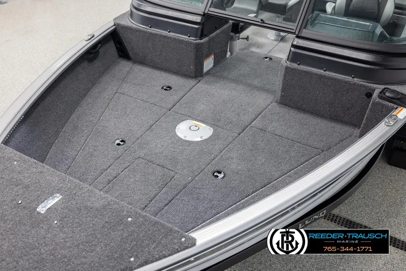 Slide: The Image of 2025 Lund 1875 Impact XS boat interior with carpeted deck and storage compartments. - 9