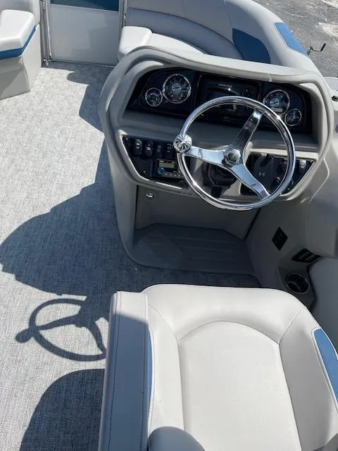 Slide: The Image of 2025 Berkshire 22 RFX LE Tri-toon Pontoon steering console with modern controls and seating. - 6