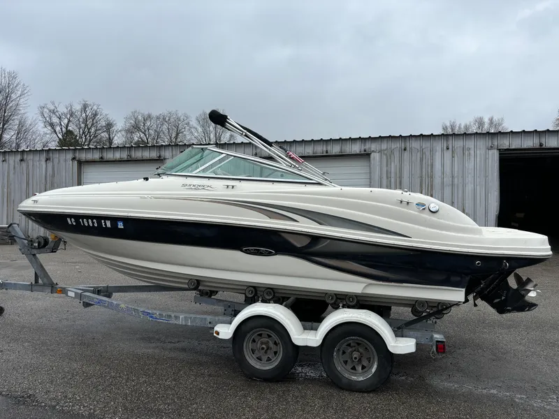 The Image of 2004 Sea Ray 200 Sundeck boat on trailer, parked outdoors. - 0