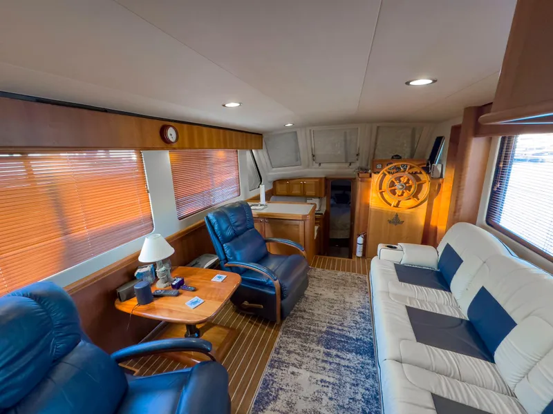 Slide: The Image of Interior of 2005 Mainship 34 Trawler with plush seating and wooden helm. - 11
