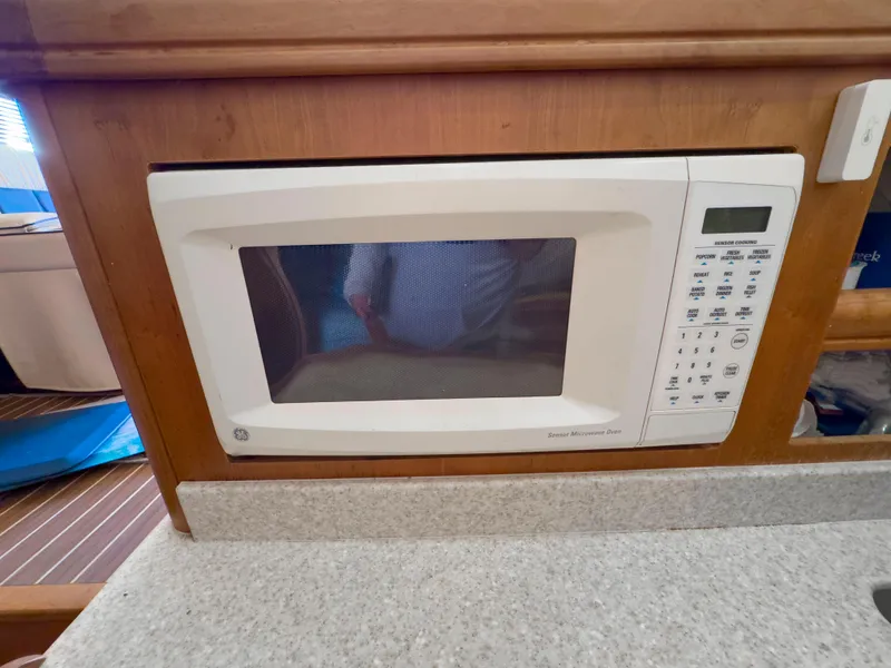 Slide: The Image of Microwave in 2005 Mainship 34 Trawler kitchen, wooden cabinetry, countertop. - 16
